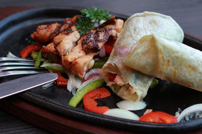 Fresh piada wrap filled with grilled vegetables and herbs